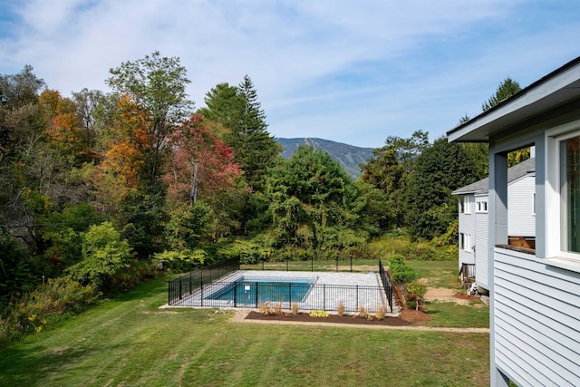 view of swimming pool featuring a mountain view and a lawn