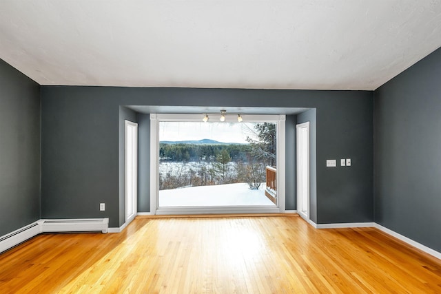 interior space with a baseboard radiator and light hardwood / wood-style floors