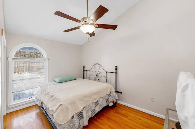 bedroom with ceiling fan, wood-type flooring, and vaulted ceiling