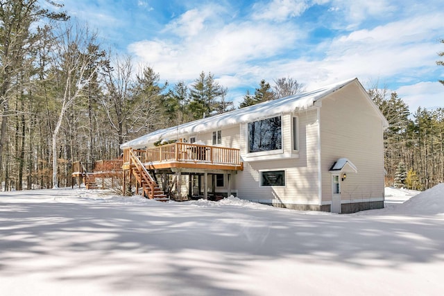 snow covered house featuring a deck