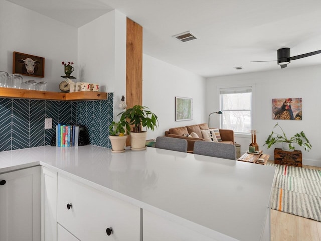 kitchen with white cabinetry, ceiling fan, and light wood-type flooring