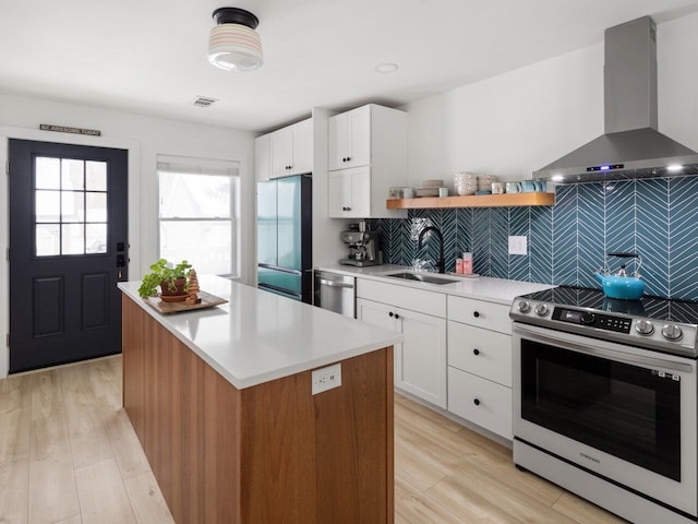 kitchen featuring appliances with stainless steel finishes, island range hood, sink, white cabinets, and a center island