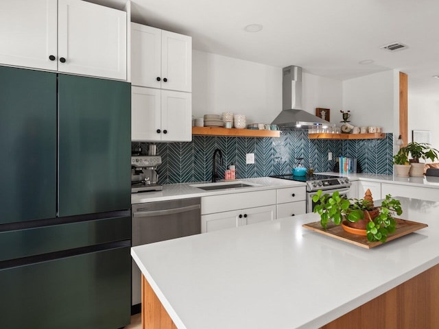 kitchen featuring appliances with stainless steel finishes, sink, extractor fan, and white cabinets