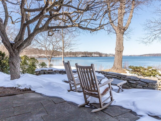 yard covered in snow featuring a water view