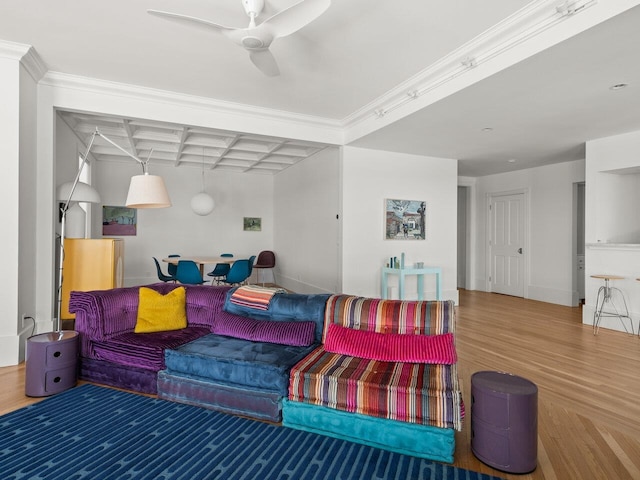 living room featuring hardwood / wood-style floors, ornamental molding, and ceiling fan