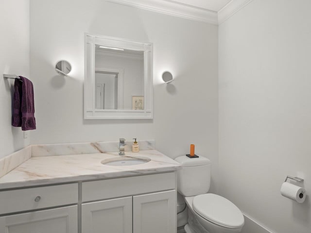 bathroom featuring vanity, ornamental molding, and toilet