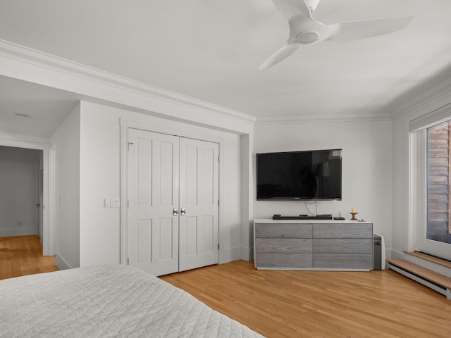 bedroom with hardwood / wood-style flooring, ornamental molding, ceiling fan, and a closet