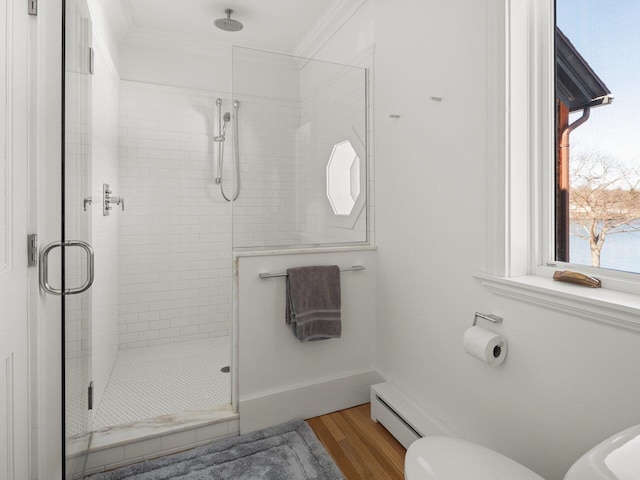 bathroom featuring ornamental molding, toilet, an enclosed shower, and wood-type flooring