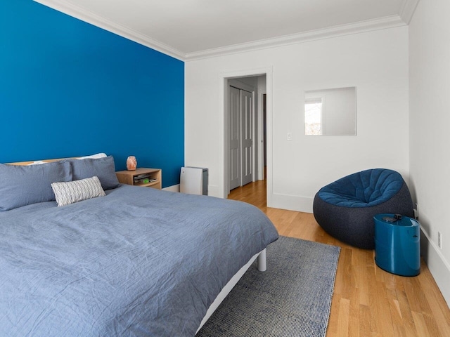 bedroom featuring ornamental molding and wood-type flooring