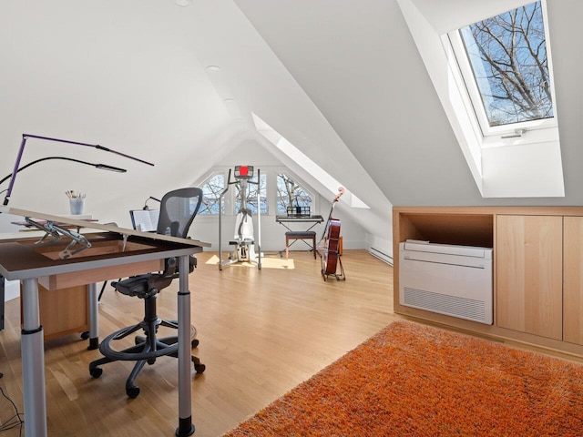 office space featuring heating unit, light hardwood / wood-style floors, vaulted ceiling with skylight, and baseboard heating