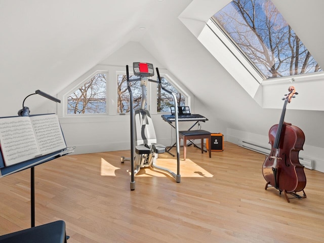 exercise area featuring lofted ceiling with skylight and light wood-type flooring