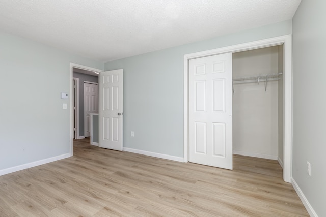 unfurnished bedroom featuring a closet, light hardwood / wood-style flooring, and a textured ceiling