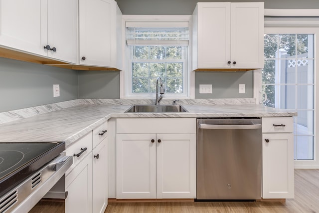 kitchen with white cabinetry, stainless steel dishwasher, light hardwood / wood-style floors, and sink