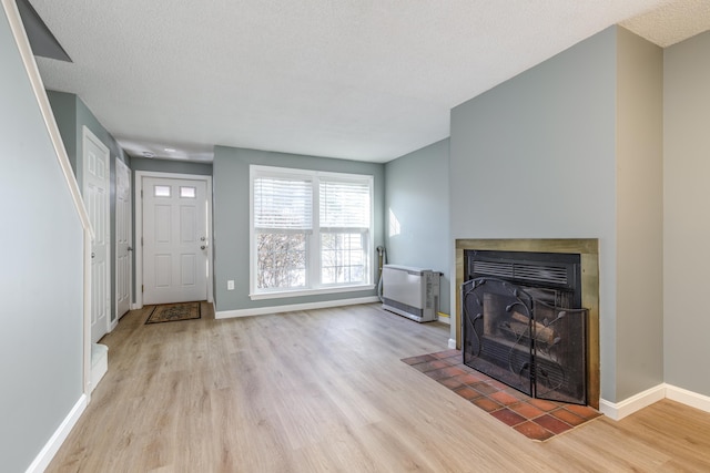 unfurnished living room with a textured ceiling and light wood-type flooring