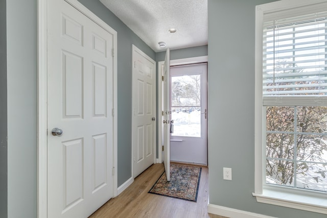 entrance foyer featuring a textured ceiling and light wood-type flooring