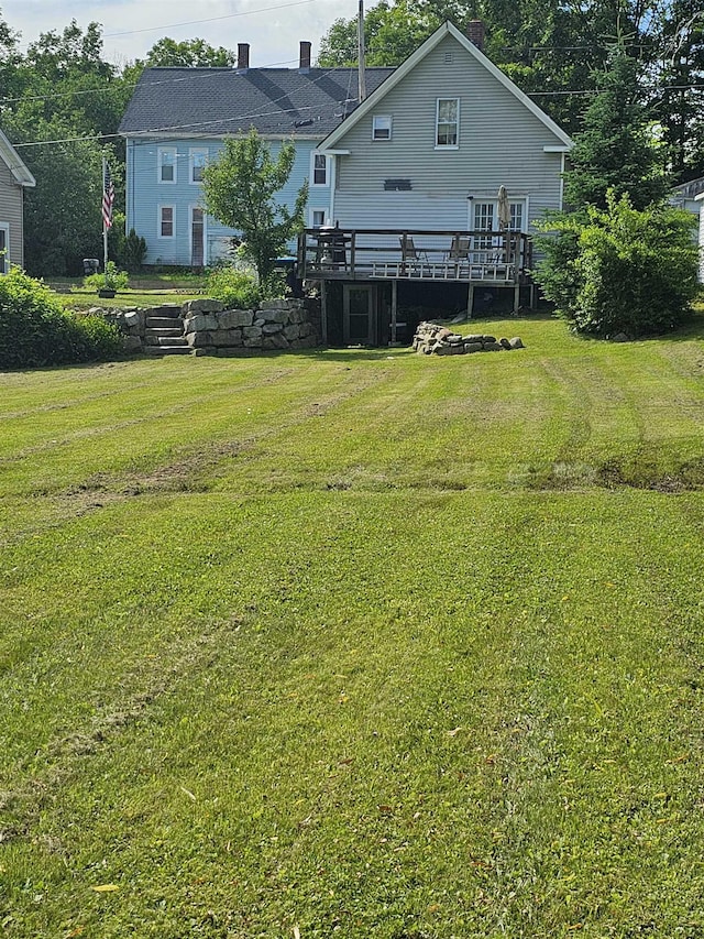 back of property with a wooden deck and a yard