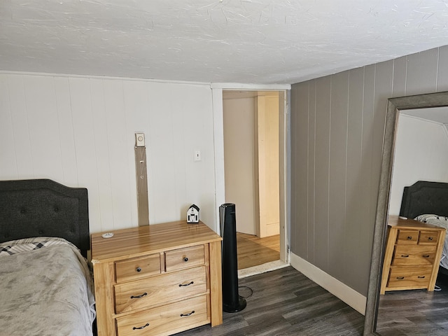 bedroom featuring dark hardwood / wood-style flooring and a textured ceiling