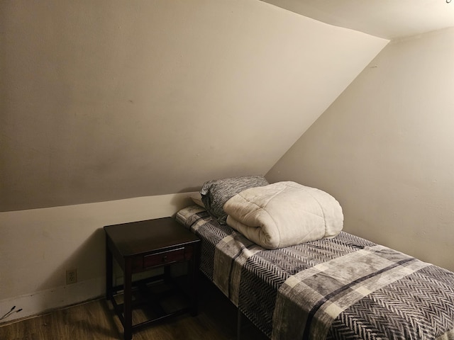 bedroom with lofted ceiling and dark hardwood / wood-style floors