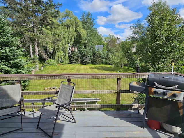 wooden terrace featuring area for grilling and a yard