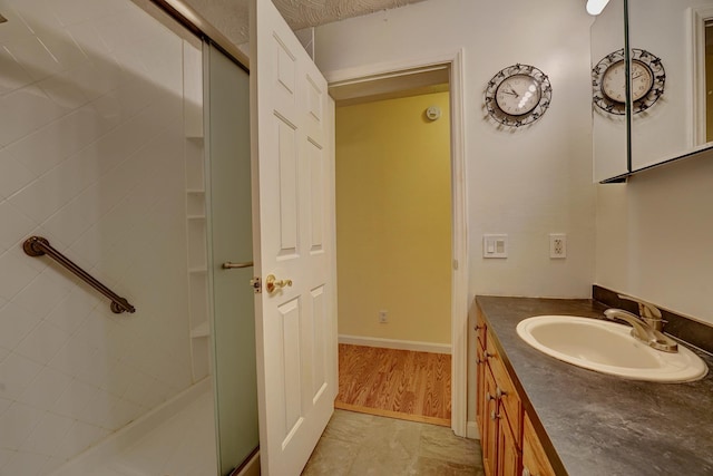 bathroom featuring vanity and a shower with door