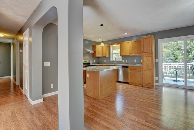 kitchen featuring sink, a kitchen island, pendant lighting, stainless steel appliances, and light hardwood / wood-style floors