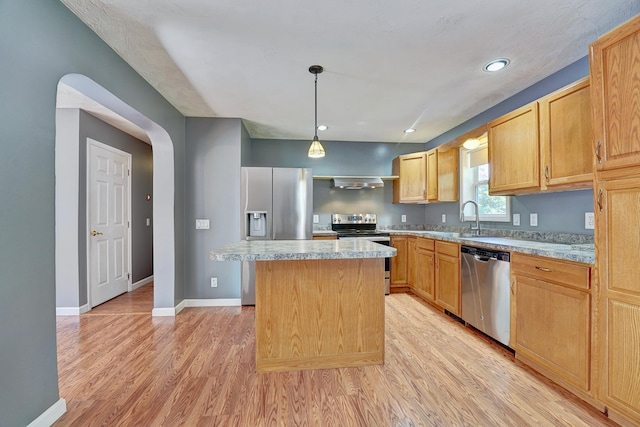 kitchen featuring sink, hanging light fixtures, light hardwood / wood-style flooring, a kitchen island, and stainless steel appliances