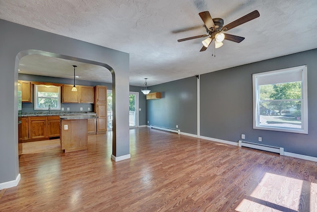 kitchen featuring hanging light fixtures, a baseboard radiator, and light wood-type flooring