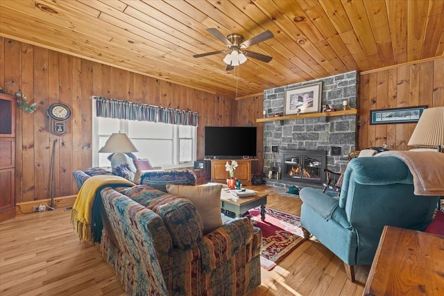 living room featuring wood ceiling, wooden walls, a fireplace, and light hardwood / wood-style floors