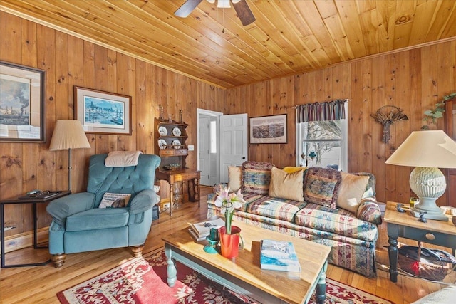 living room featuring hardwood / wood-style flooring, ceiling fan, wood walls, and wooden ceiling