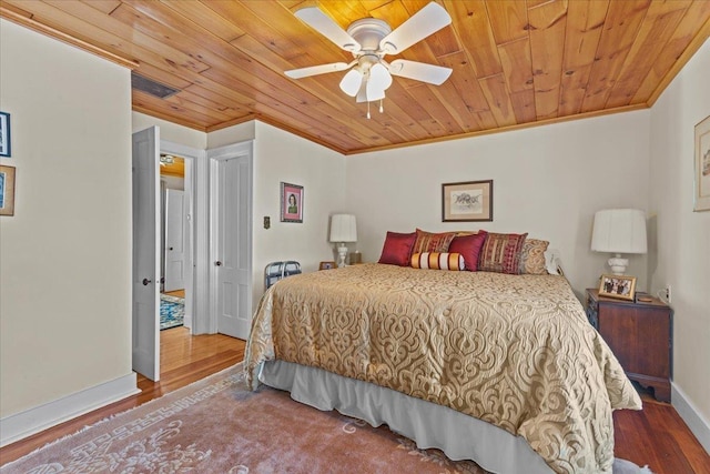 bedroom featuring hardwood / wood-style flooring, ceiling fan, ornamental molding, and wooden ceiling