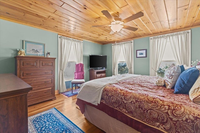 bedroom with ceiling fan, light wood-type flooring, crown molding, and wood ceiling