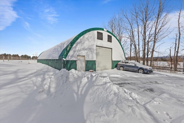 snow covered structure featuring a garage