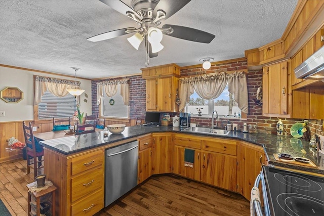 kitchen with sink, dark wood-type flooring, stainless steel appliances, a textured ceiling, and kitchen peninsula