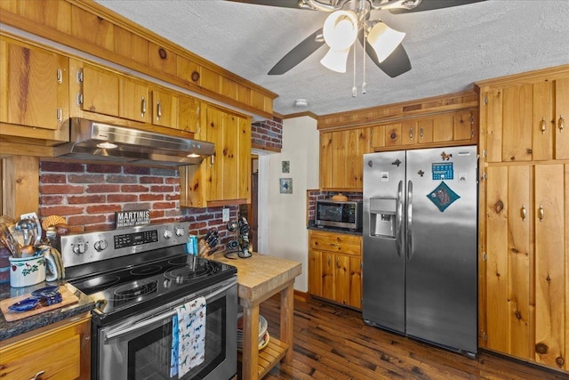 kitchen with ornamental molding, ceiling fan, stainless steel appliances, dark wood-type flooring, and a textured ceiling