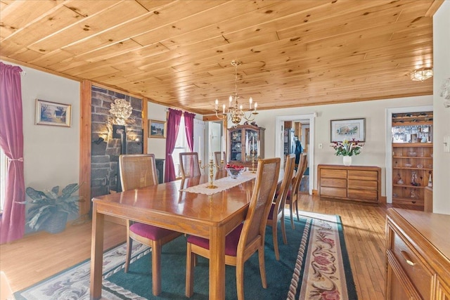 dining room with wooden ceiling, an inviting chandelier, and light hardwood / wood-style flooring