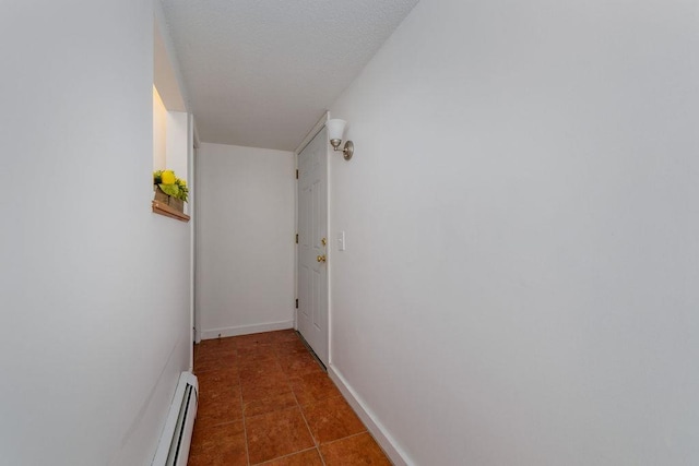 hallway featuring dark tile patterned flooring and a baseboard radiator