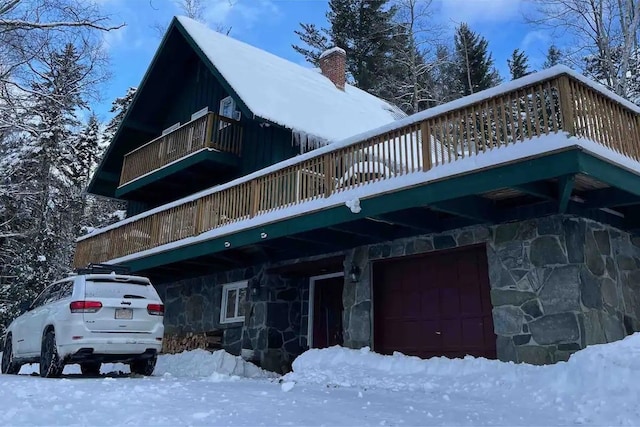 snow covered property featuring a garage