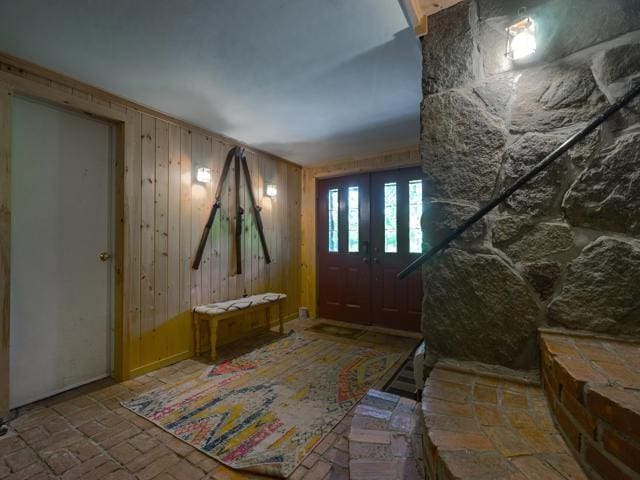 foyer entrance featuring wood walls