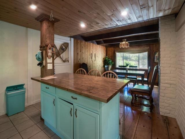 kitchen with a center island, light tile patterned floors, wooden counters, and wood ceiling