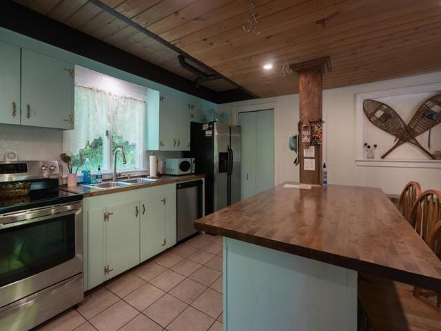 kitchen featuring sink, wood ceiling, light tile patterned floors, and appliances with stainless steel finishes