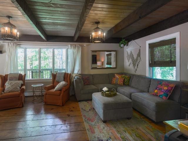 living room with an inviting chandelier, plenty of natural light, beam ceiling, and hardwood / wood-style floors