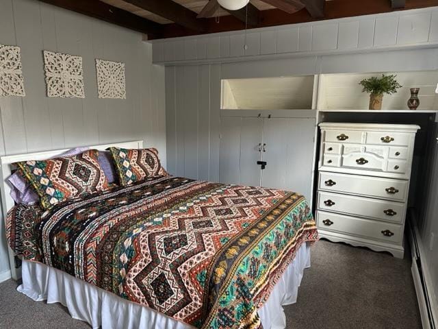 bedroom with beamed ceiling, ceiling fan, wooden walls, and carpet floors