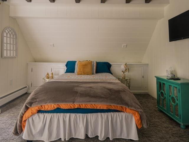 carpeted bedroom featuring a baseboard heating unit and lofted ceiling with beams