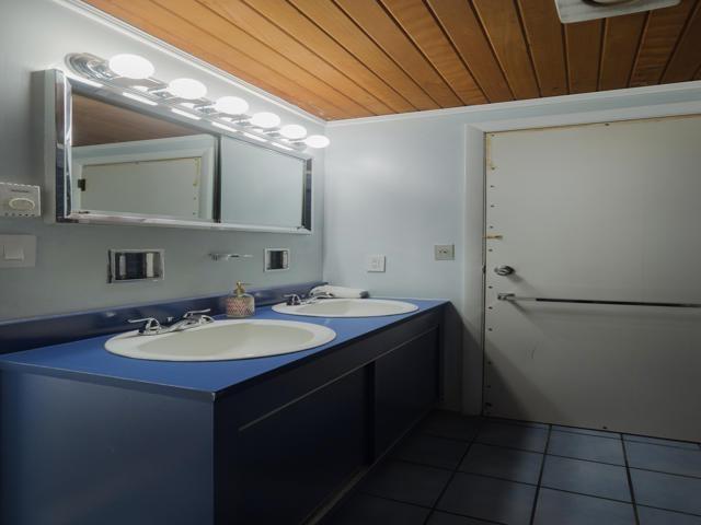 bathroom with tile patterned flooring, sink, and wooden ceiling