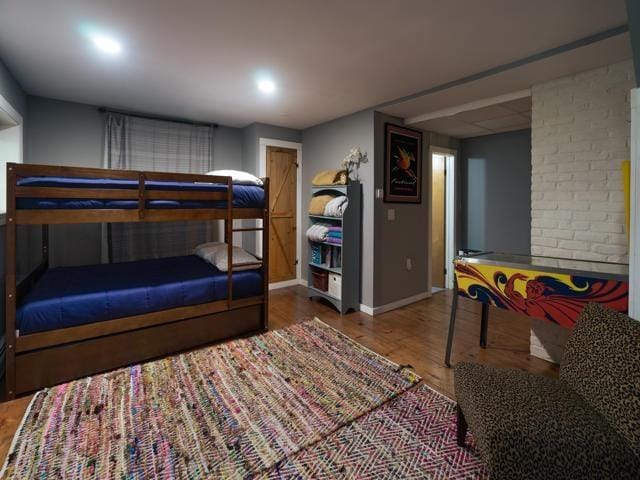 bedroom featuring hardwood / wood-style floors and a drop ceiling