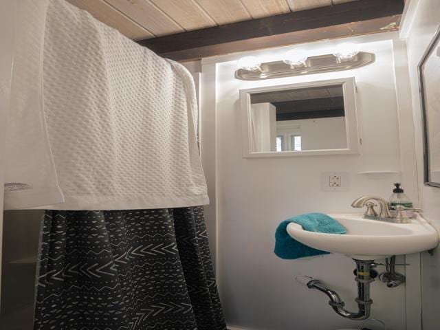 bathroom featuring wood ceiling and beamed ceiling