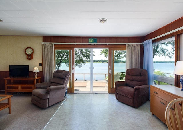 living room featuring a water view and wood walls