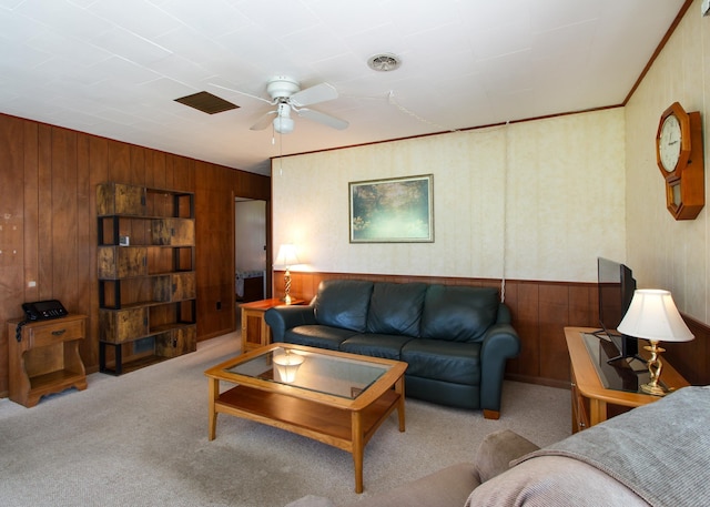 carpeted living room featuring crown molding and ceiling fan