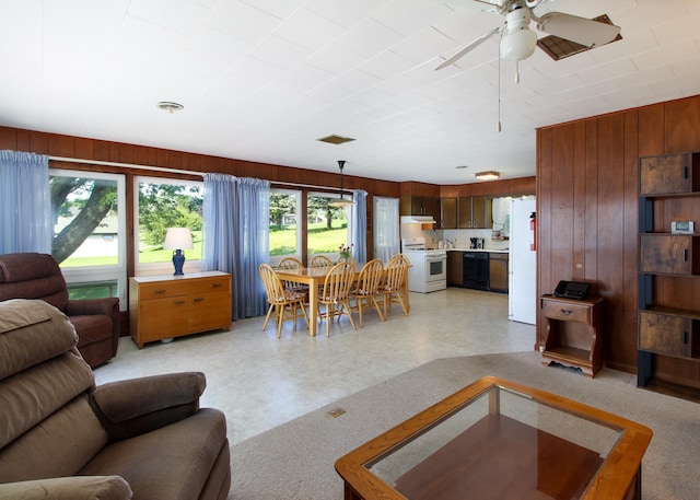 living room with wooden walls and ceiling fan