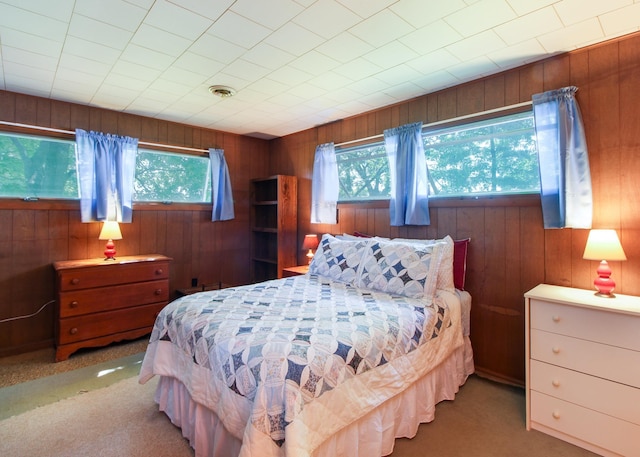 bedroom with wooden walls and carpet